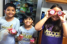 Kids eating fruit from Village Harvest